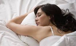 A woman sleeping with her arm tucked beneath her pillow and head